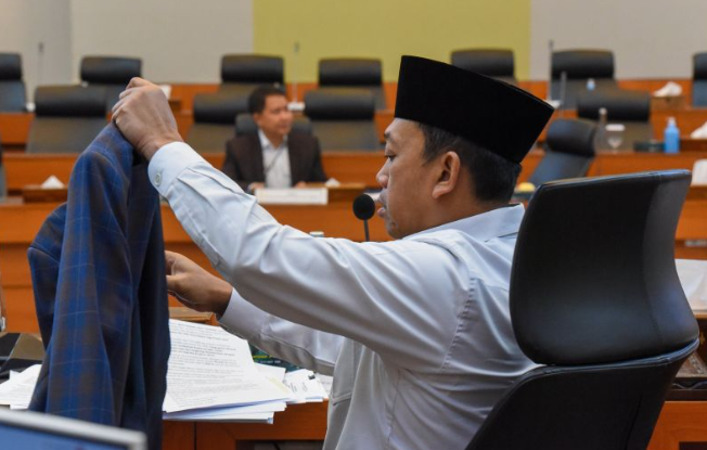 Ketua Panitia Khusus (Pansus) Angket Haji Nusron Wahid (kanan) mengenakan jasnya saat memimpin Rapat Pansus Angket Haji yang menghadirkan Direktur Jenderal Penyelenggaraan Haji dan Umrah (PHU) Kementerian Agama Hilman Latief (kiri) di Ruang Badan Anggaran DPR, Gedung Nusantara II, Kompleks Parlemen, Senayan, Jakarta, Rabu (21/8/2024). ANTARA FOTO/Indrianto Eko Suwarso